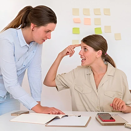 A woman wearing a blue shirt, reflecting her meticulous nature and attention to detail, stands with poise and confidence.